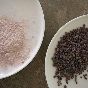 Cristales de Kala Namak o sal negra del Himalaya y en formato molida sobre un plato