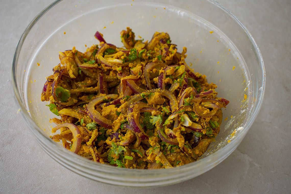 Preparación de Bhajis de cebolla con cebolla, especias y harina de garbanzo
